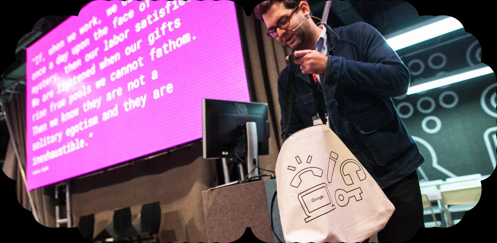 Rob Giampietro reaching into a SPAN tote bag onstage.