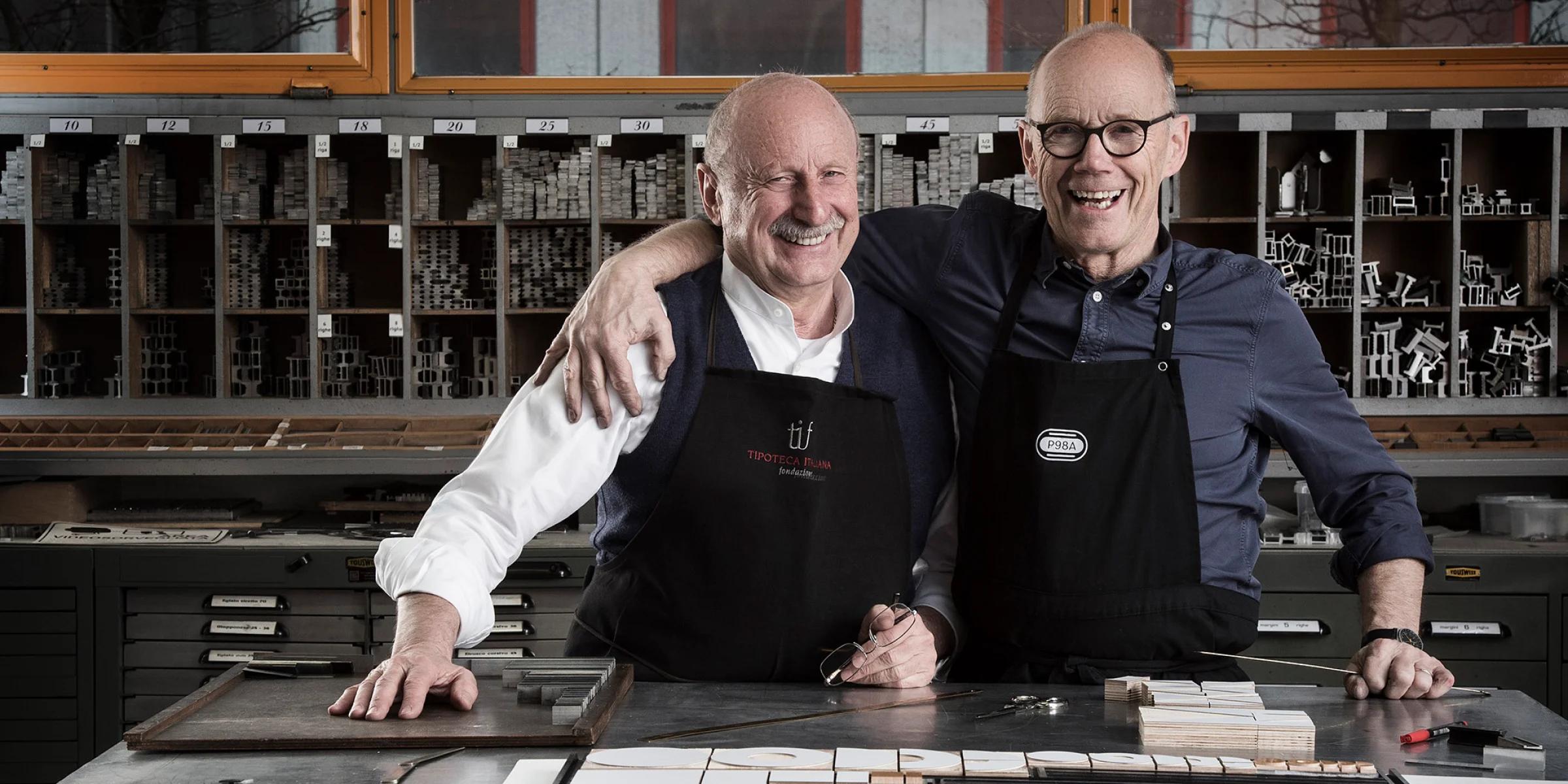 Two men laughing in a workshop setting